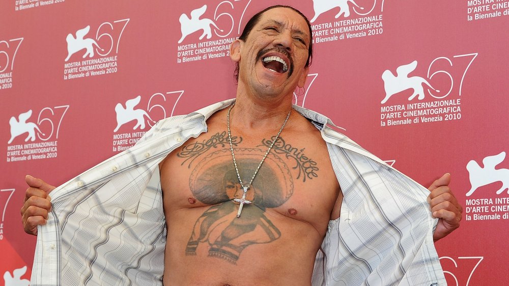 Danny Trejo baring his chest at a photocall for Machete during the 67th Annual Venice Film Festival 