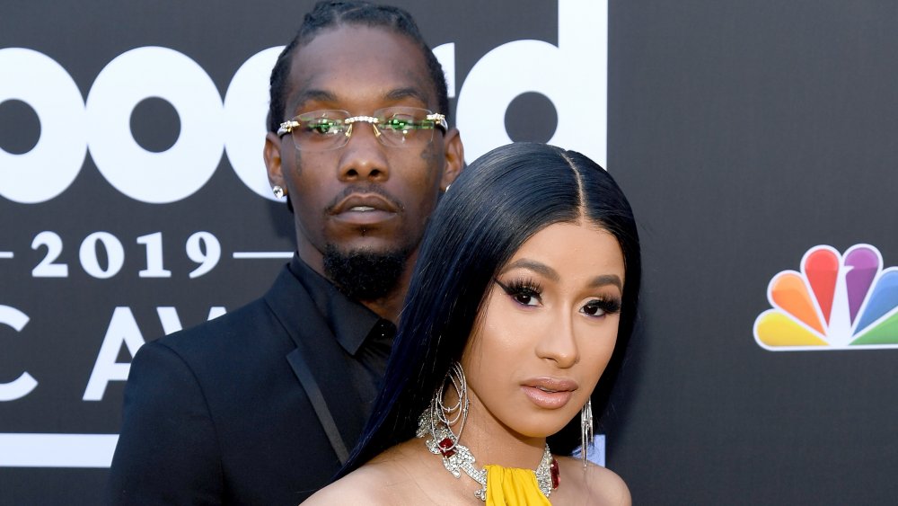 Offset standing behind Cardi B with his arms around her 