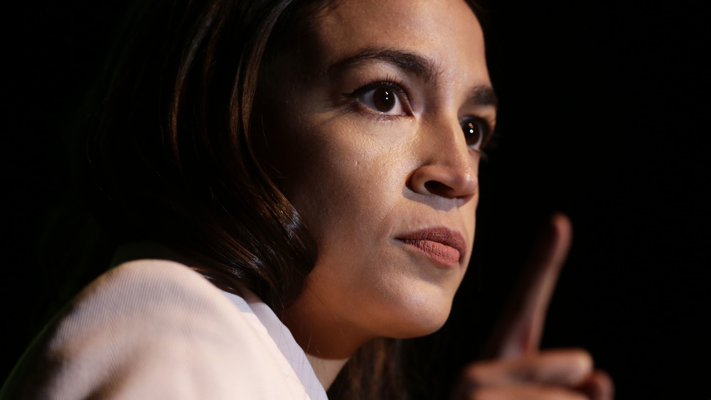 Alexandria Ocasio-Cortez speaking with a serious expression