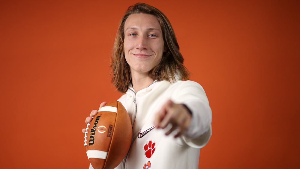 Trevor Lawrence holding a football and pointing at the camera 