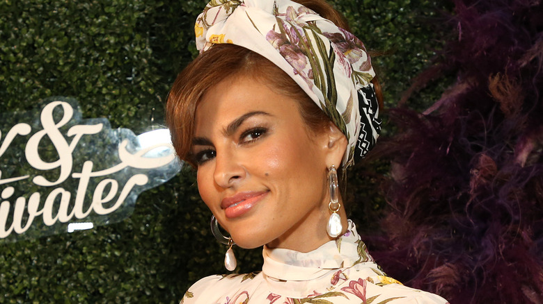 Eva Mendes smiles wearing floral hat