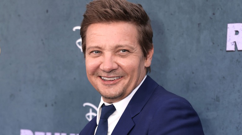 Jeremy Renner smiling in blue suit