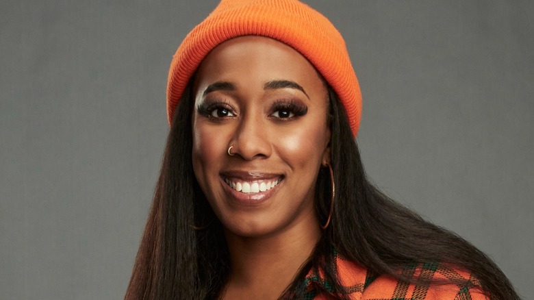 Monay smiling in an orange beanie